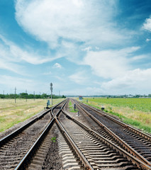 Fototapeta na wymiar crossing of railroad to horizon under cloudy sky