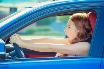 displeased angry aggressive woman driving car screaming