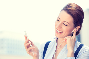 Business woman walking on street listening music mobile phone