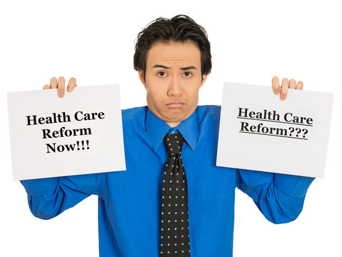 Confused Business Man Holding Healthcare Reform Sign Puzzled