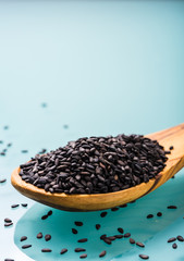 black sesame seeds on a olive wood spoon