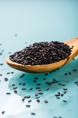 black sesame seeds on a olive wood spoon