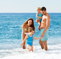 Naklejka premium Family with two kids on beach