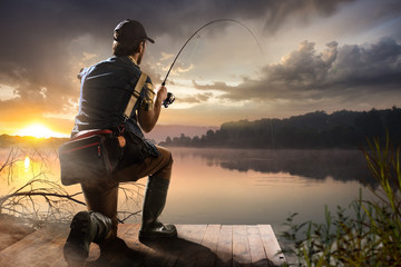 Jonge man aan het vissen bij mistige zonsopgang