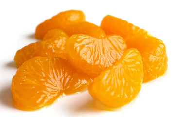 Group of mandarin segments in light syrup on white.