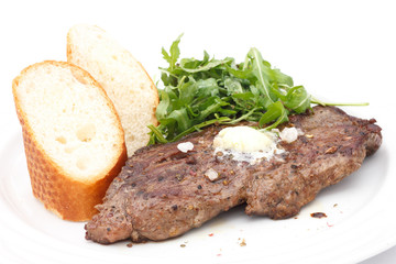 Roast pork rib eye steak, butter, baguette and salad.