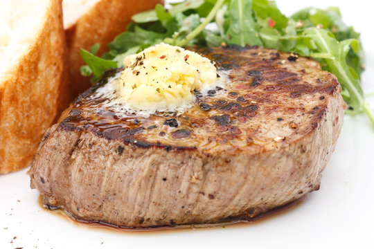 Roast pork tenderloin fillet steak topped with melting butter.