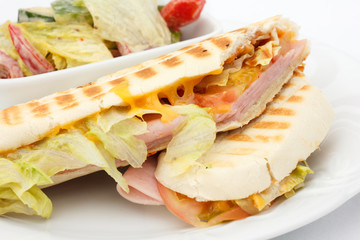 Cheese and ham panini with salad.