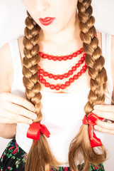 A young beautiful girl wearing folk costume with long tresses