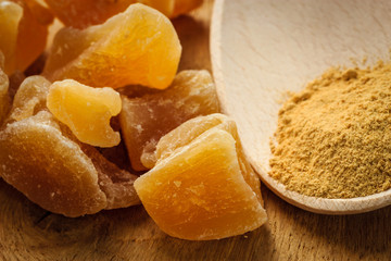 Candied and ground ginger on rustic table