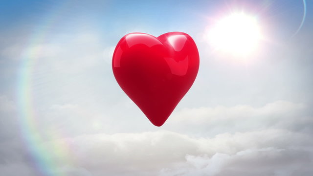 Red heart turning and exploding over blue sky