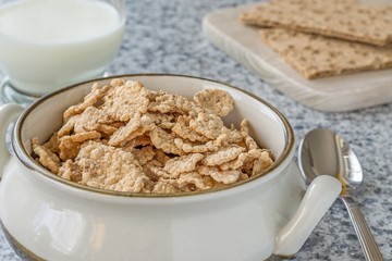 A bowl of bran flakes cereal on the breakfast table