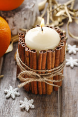 Obraz na płótnie Canvas Candle decorated with cinnamon sticks, christmas decoration