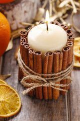 Candle decorated with cinnamon sticks, christmas decoration