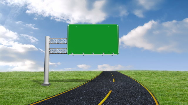 Green road sign against blue sky