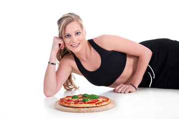 Model Frau im Sportoutfit liegt mit Pizza am Boden Porträt