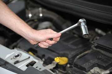 Auto mechanic with chrome plated wrench in closeup