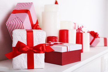 Christmas boxes and candles on mantelshelf, close-up