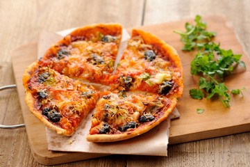Pizza with olives and salmon and fresh greens
