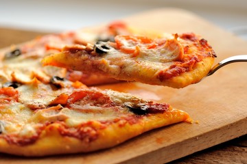 Pizza with olives and salmon and fresh greens