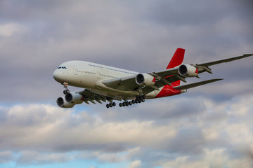 Plane flying in sunset sky.