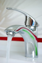 The stream of water flowing from the tap