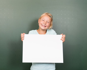 Mädchen hält Schild vor Tafel