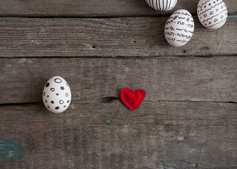 Easter eggs and red heart on wooden background
