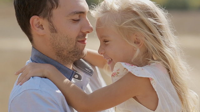Father having fun holding his little daughter in arms in slow
