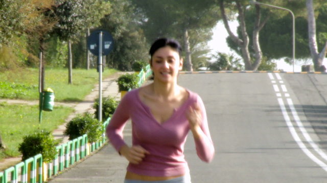 Medium shot of beautiful woman jogging on street