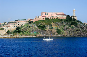Naklejka premium Sailboat cruising in front of Portoferraio on Elba island