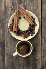 cup of coffee with cinnamon sticks on wood