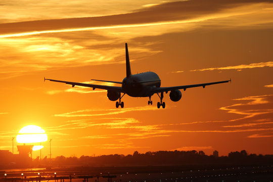 Flugzeug beim Landen auf Flughafen mit Sonnenuntergang