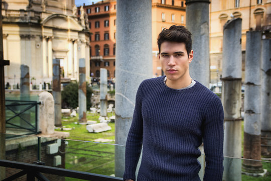 Young man in Rome in front of Foro Traiano and Fori Imperiali