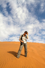 Woman tourist climbing a sand dune