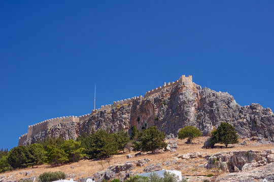 Medieval fortifications on top of the rock in Lindos .