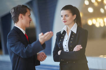 Young business woman and businessman talking in the hallway