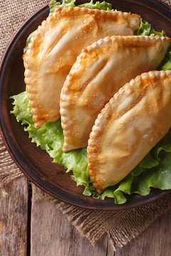 empanadas on a plate with lettuce close-up. vertical top view