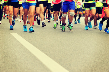 Naklejka premium marathon athletes legs running on city road