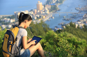 young beautiful asian use digital tablet at mountain peak