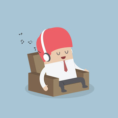 Businessman relaxing on sofa and listening to his headphones