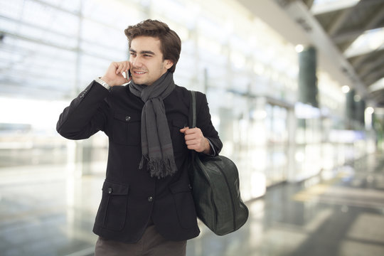 Young businessman talking on mobile phone  in airport