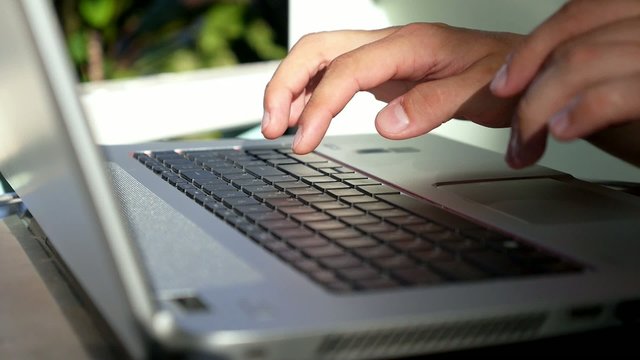 Closeup of Businessman Hand Typing on Laptop Keyboard