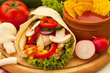 Fried spicy chicken and vegetables wrapped in a tortilla roll