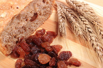 Baked wholemeal bread, raisins and ears of wheat