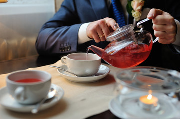 A man pours tea into a cup