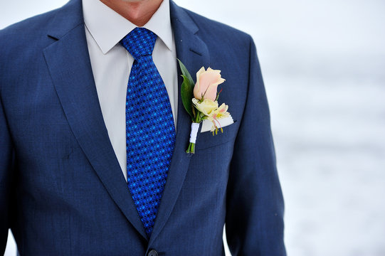 rose boutonniere on suit of the groom