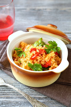 Tasty pilaf in a pot on wooden boards