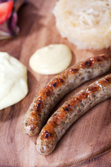 zwei Bratwürste auf einer Holzplatte