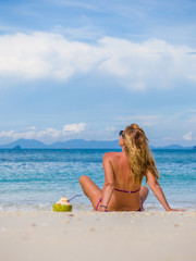 Naklejka premium Woman on the beach with coconut drink